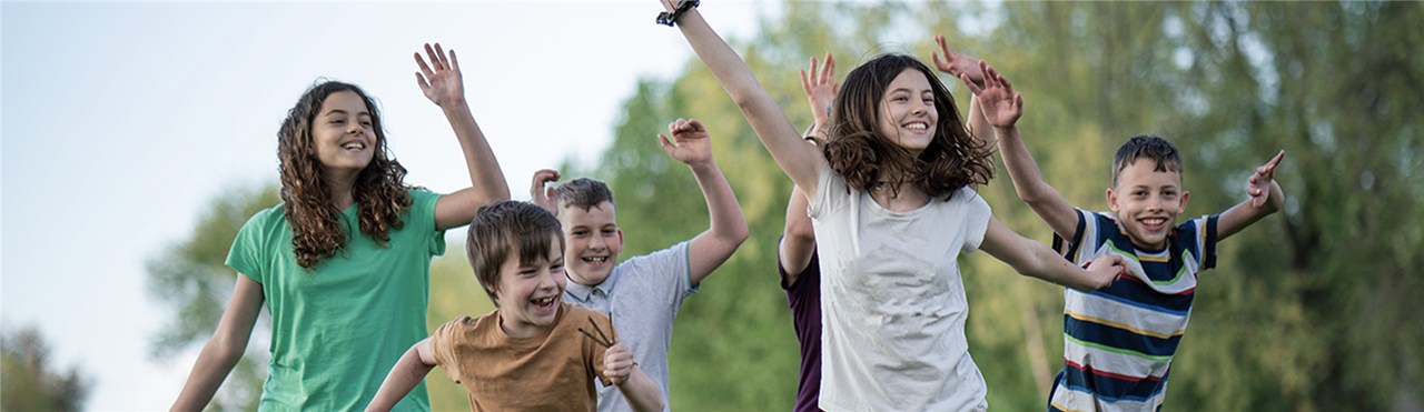 Kinder die zusammen auf einer Wiese spielen