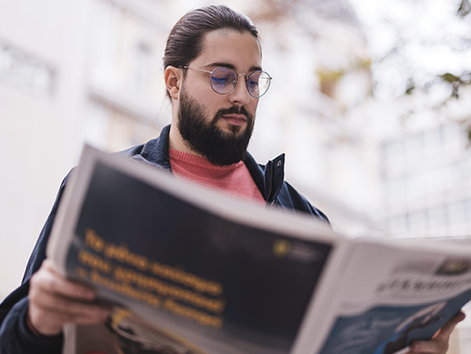 Mann liest eine Zeitung im Freien in einer lässigen urbanen Umgebung