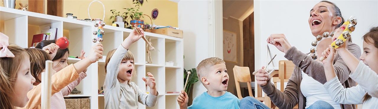 Erzieherin spielt mit Kindern verschiedene Instrumente